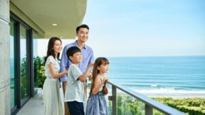 Família diversa visitando imóvel à beira-mar em São Pedro da Aldeia, transmitindo satisfação e empolgação.