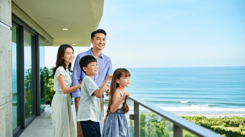 Família diversa visitando imóvel à beira-mar em São Pedro da Aldeia, transmitindo satisfação e empolgação.